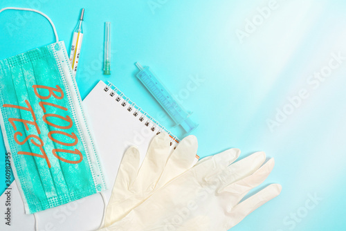 Conceptual hand writing showing Blood Test. Concept meaning Extracted blood sample from an organism to perfom a laboratory analysis Set of medical equipment with notepad for health assessment photo