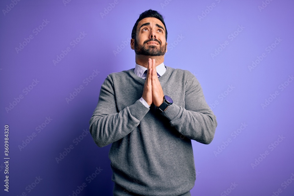 Handsome businessman with beard wearing casual tie standing over purple background begging and praying with hands together with hope expression on face very emotional and worried. Begging. Handsome businessman with beard wearing casual tie standing over purple background begging and praying with hands together with hope expression on face very emotional and worried. Begging.