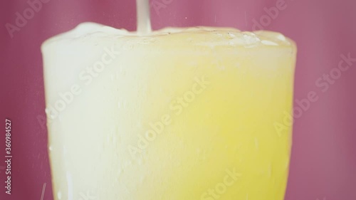 Lemonade spills over a glass