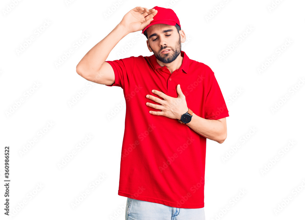 Young handsome man with beard wearing delivery uniform touching forehead for illness and fever, flu and cold, virus sick Young handsome man with beard wearing delivery uniform touching forehead for illness and fever, flu and cold, virus sick