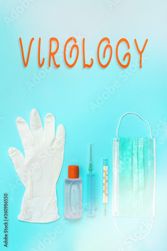 Writing note showing Virology. Business concept for branch of science dealing with the variety of viral agents and disease Primary medical precautionary equipments for health care protection photo