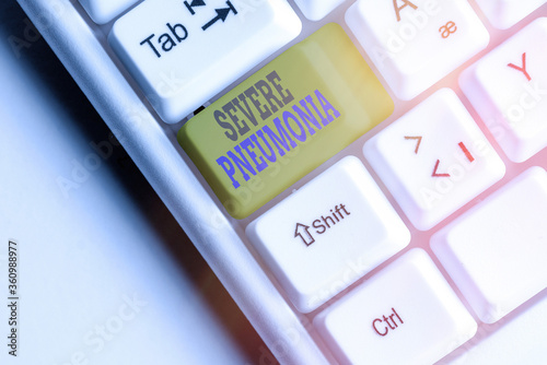 Text sign showing Severe Pneumonia. Business photo showcasing acute disease that is marked by inflammation of lung tissue White pc keyboard with empty note paper above white key copy space