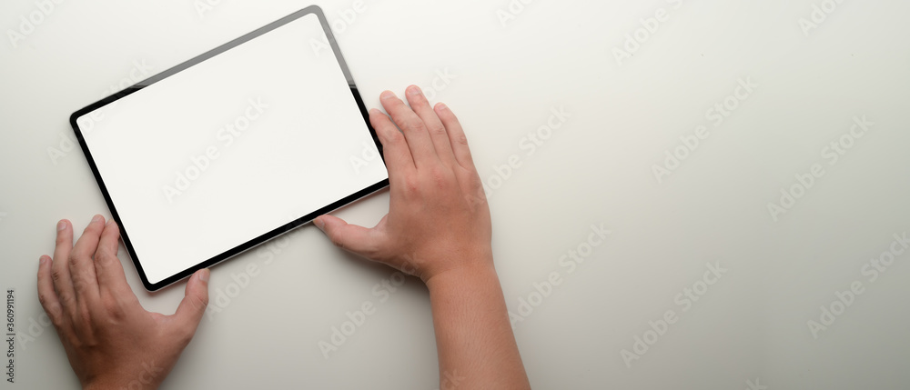 Male entrepreneur using mock-up above white office desk with copy space Male entrepreneur using mock-up above white office desk with copy space