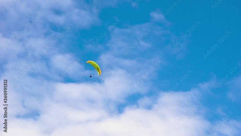 Skydiver paraglider in a fly. Adrenaline and extreme sport. Beautiful tranquil and calm time in nature in cloudy blue sky daylight. Skydiver paraglider in a fly. Adrenaline and extreme sport. Beautiful tranquil and calm time in nature in cloudy blue sky daylight.