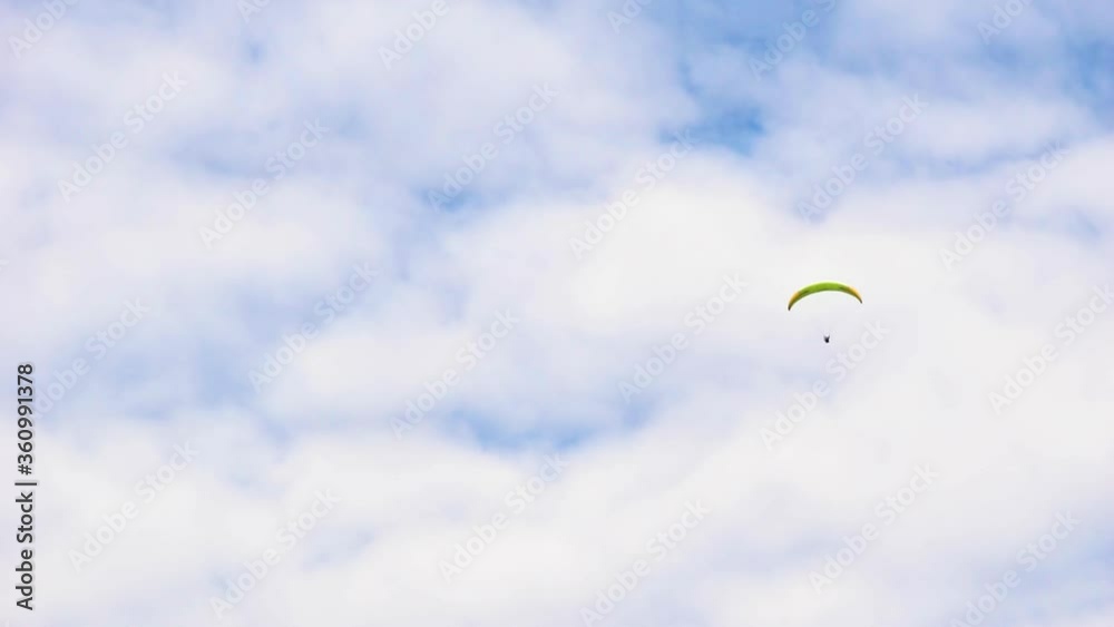Paraglider flying in clouds. Summer sports, active lifestyle, activity moving downward. Skydiver paraglider. Adrenaline and extreme sport. Beautiful calm time in nature in cloudy blue sky daylight. Paraglider flying in clouds. Summer sports, active lifestyle, activity moving downward. Skydiver paraglider. Adrenaline and extreme sport. Beautiful calm time in nature in cloudy blue sky daylight.