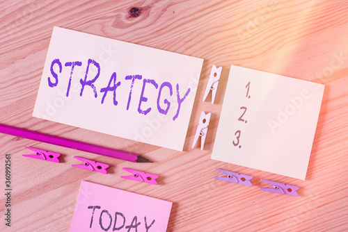 Word writing text Strategy. Business photo showcasing action plan or strategy designed to achieve an overall goal Colored clothespin papers empty reminder wooden floor background office photo