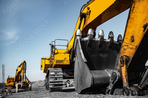 Group of yellow excavator working on construction open mining site photo