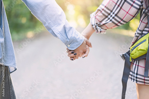 Asian Couple summer vacation travel. Man and Woman walking on romantic honeymoon promenade holidays holding the hand of boyfriend following ..