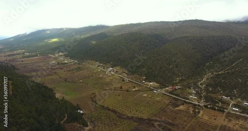 Valley with houses, acriculture and forrest. Dusty day. Aerial. photo