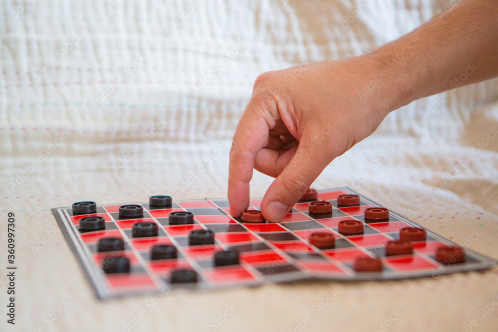 checkers close-up. black and red map. the hand holds the chip. games for development of logic checkers close-up. black and red map. the hand holds the chip. games for development of logic