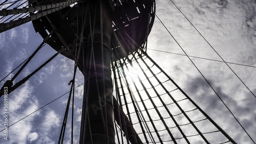 Bild auf Leinwand Low angle shot of a ship's main mast under the cloudy sky
