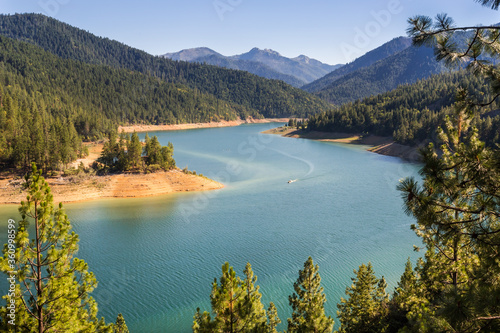 Beautiful landscape with turquoise water of a mountain lake in the foreground and a mountain range in the background. View from above in golden hour. Location is Applegate Lake in Oregon, USA 