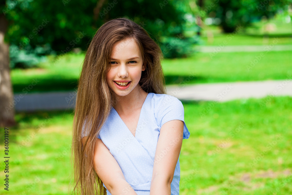Portrait of a young beautiful brunette  girl in summer park