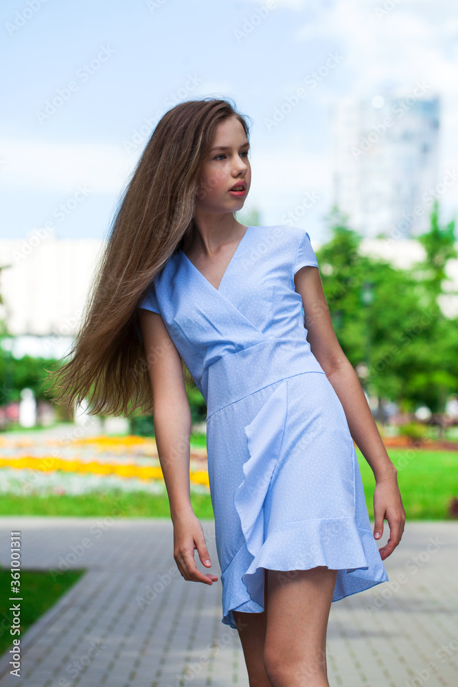 Portrait of a young beautiful teenager girl in blue dress