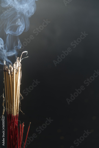 Incense burning incense, white smoke, black background, used as background image Paying homage to the sacred objects of the people of Buddhism according to their beliefs and beliefs.