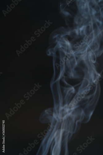 Blurred images of white smoke, black background conceptualization.