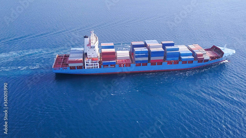 Large container ship at sea, loaded with various container brands. ULCV container ship sails on open water fully loaded with containers and cargo.