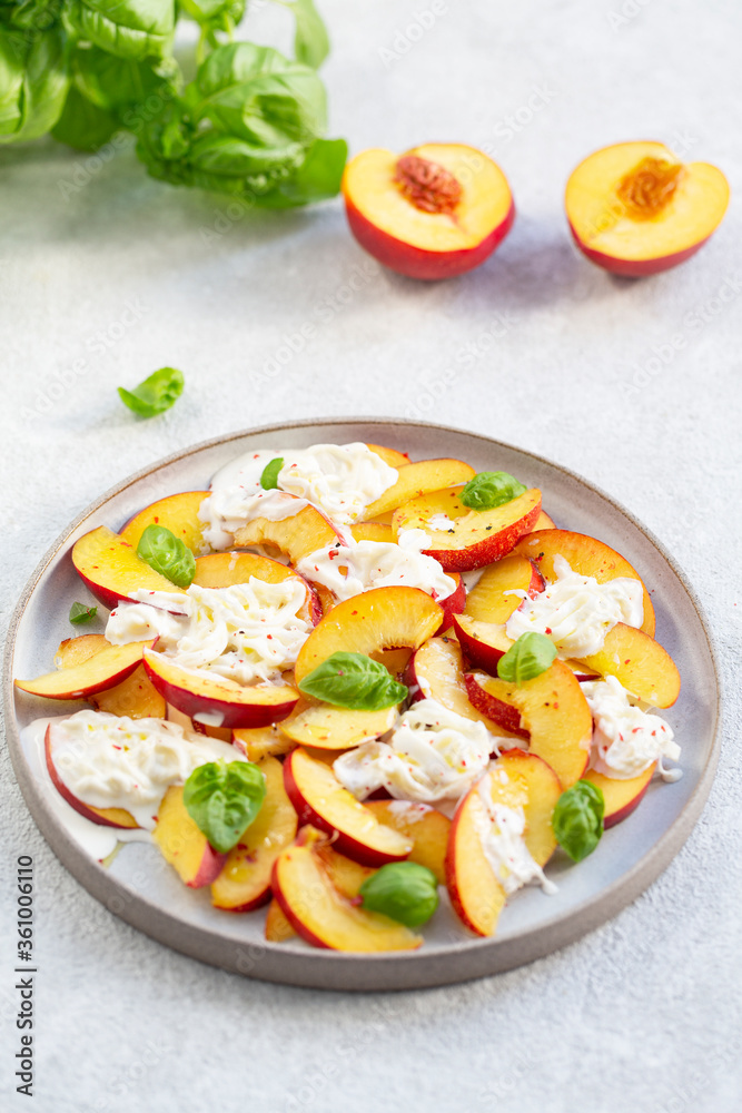 Fresh salad with peaches, Italian Stracciatella cheese, Basil, olive oil and honey. Summer salad, healthy food concept. Selective focus