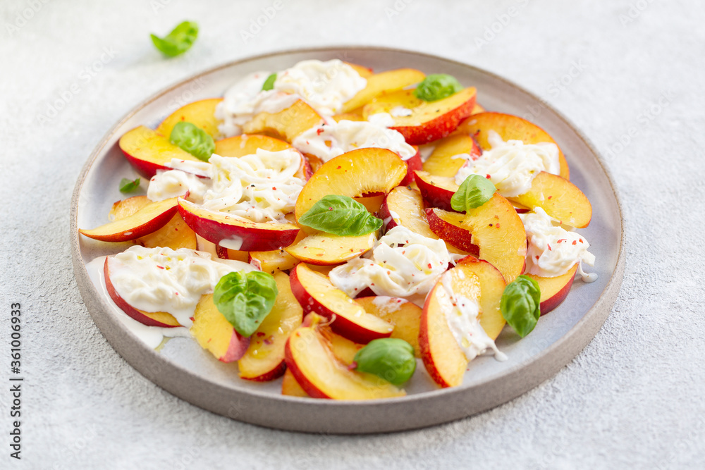 Fresh salad with peaches, Italian Stracciatella cheese, Basil, olive oil and honey. Summer salad, healthy food concept. Selective focus Fresh salad with peaches, Italian Stracciatella cheese, Basil, olive oil and honey. Summer salad, healthy food concept. Selective focus