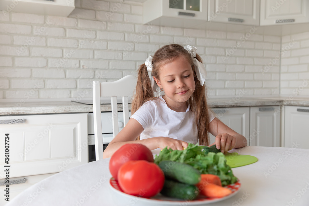 little girl in the kitchen cutting vegetables little girl in the kitchen cutting vegetables