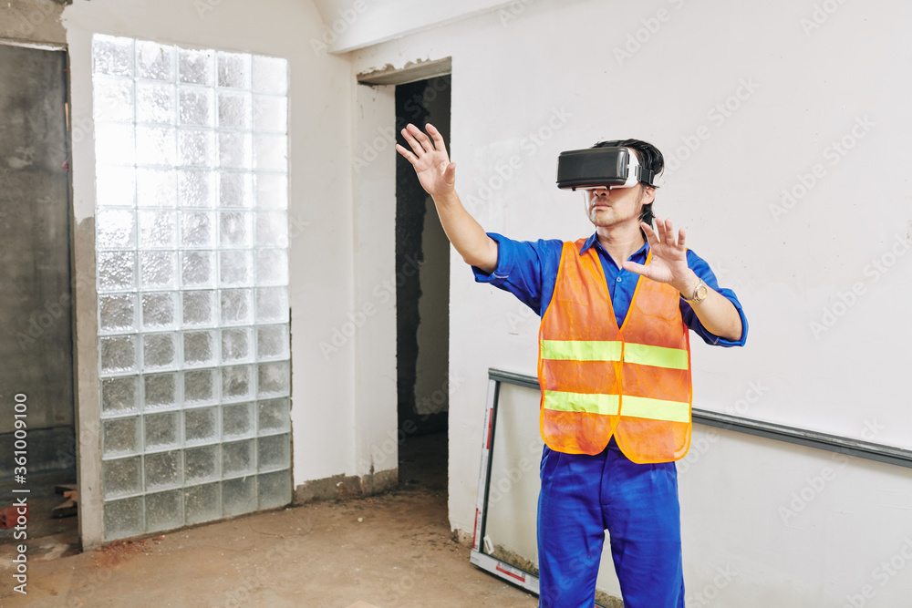 Contractor using virtual reality glasses to visualize project of apartment he is working on Contractor using virtual reality glasses to visualize project of apartment he is working on