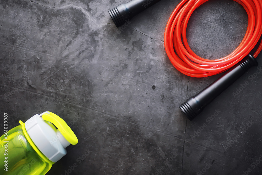 Jump rope. Physical education. Sports exercise equipment. Rope exercises routine. Pink jump rope phone with a stopwatch and water on the table. Jump rope. Physical education. Sports exercise equipment. Rope exercises routine. Pink jump rope phone with a stopwatch and water on the table.