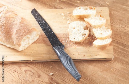 Bread with a knife on the chopping board.