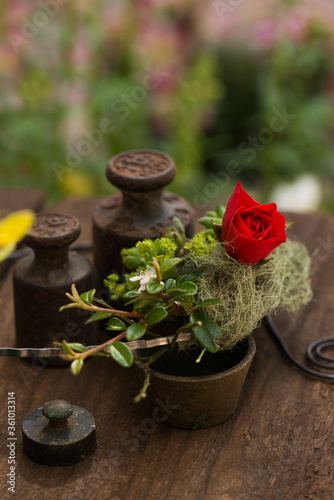 Little flower wreath with rusty weights on a garden table