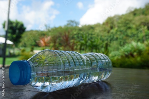 Selective focus shot of a half-empty water bottle on a surface captured at daylight