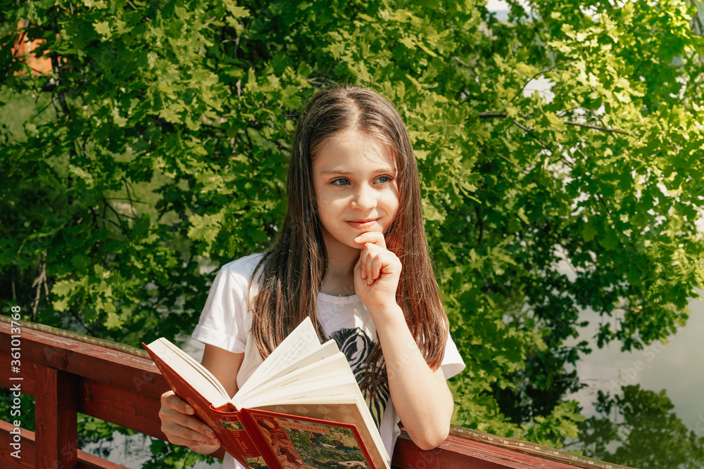 A little cute girl reading a book in the park A little cute girl reading a book in the park