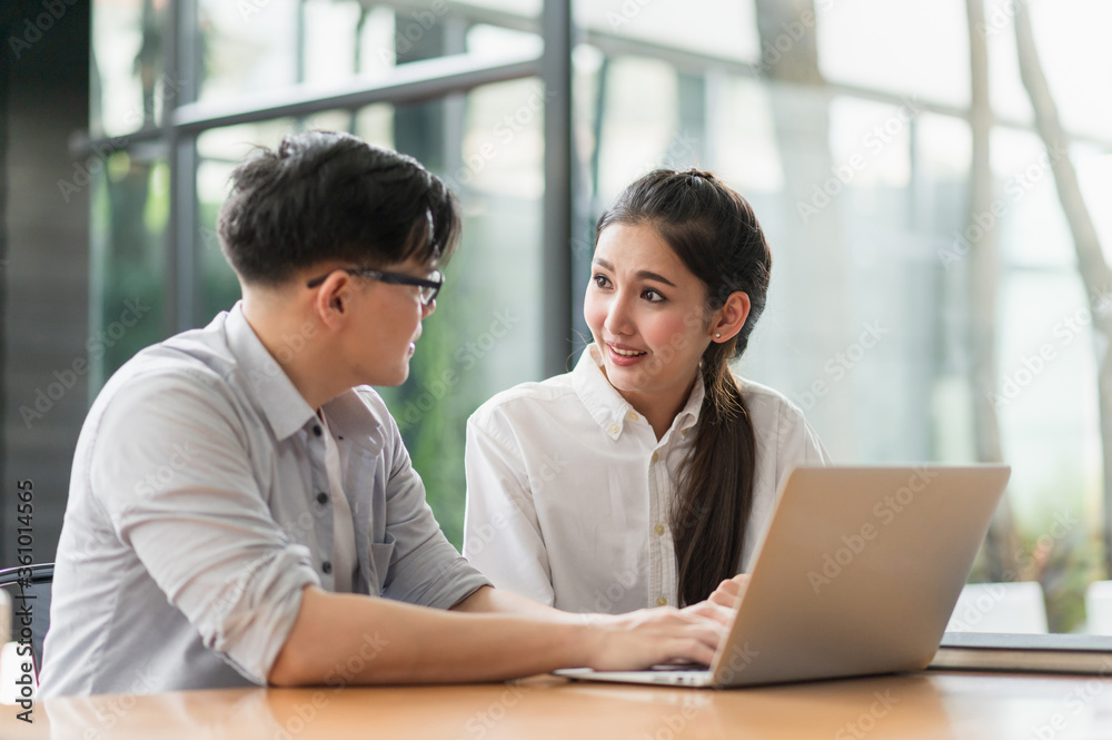Asian business people man and woman conference talking and working with laptop together. Young couple work at home. Asian business people man and woman conference talking and working with laptop together. Young couple work at home.