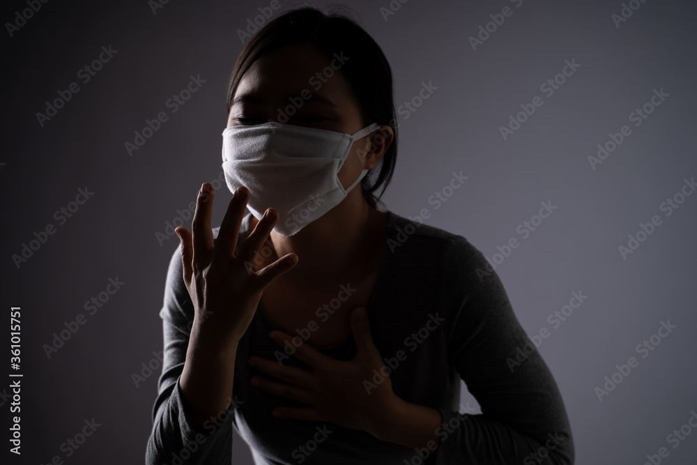 Asian woman wearing protective face mask was sick with sore throat standing isolated on background. Asian woman wearing protective face mask was sick with sore throat standing isolated on background.