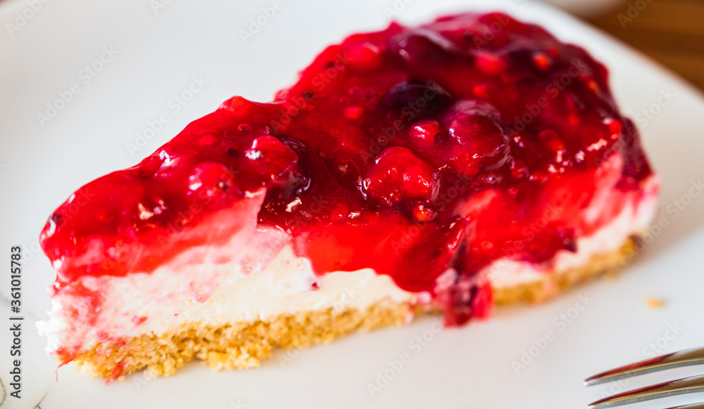 A closeup shot of a piece of fresh tasty cherry cheesecake on a white plate A closeup shot of a piece of fresh tasty cherry cheesecake on a white plate