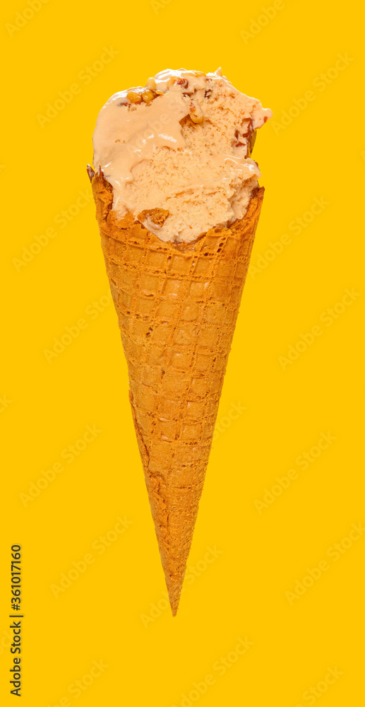 side view milk tea flavor ice cream cone with couple of bites on a yellow background side view milk tea flavor ice cream cone with couple of bites on a yellow background