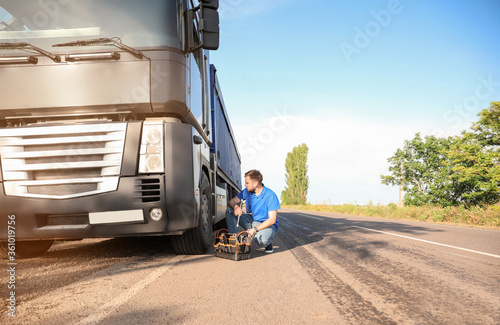Male driver repairing big t...