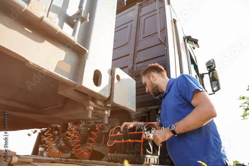 Male driver repairing big t...