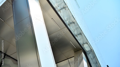 Combination of metal and glass wall material. Steel facade on columns. Abstract modern architecture. High-tech minimalist office building. Contemporary business architecture abstract fragment.