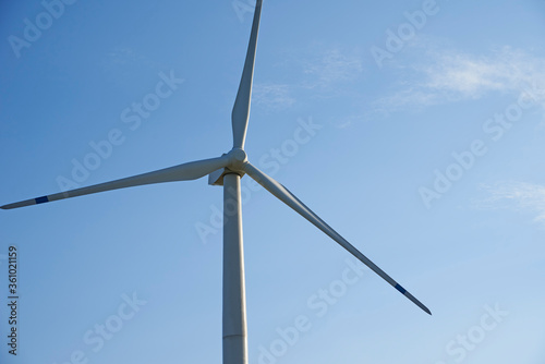 Wind turbine against blue sky. Wind power energy concept © Lazy_Bear