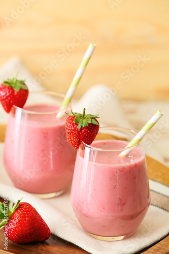 Glasses of tasty strawberry smoothie on table