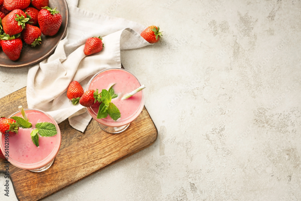 Glasses of tasty strawberry smoothie on grey background Glasses of tasty strawberry smoothie on grey background