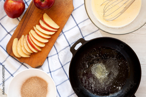 Cooking Apple Dutch Pannekoek Pancake on a white wooden background, top view. Overhead, from above. photo