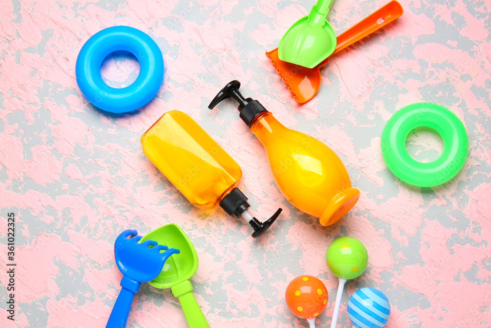 Sunscreen cream with beach sand toys on color background Sunscreen cream with beach sand toys on color background