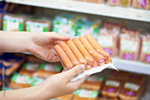Sausages in hands of buyer in shop