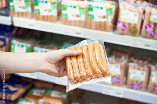 Sausages in hand of buyer in shop