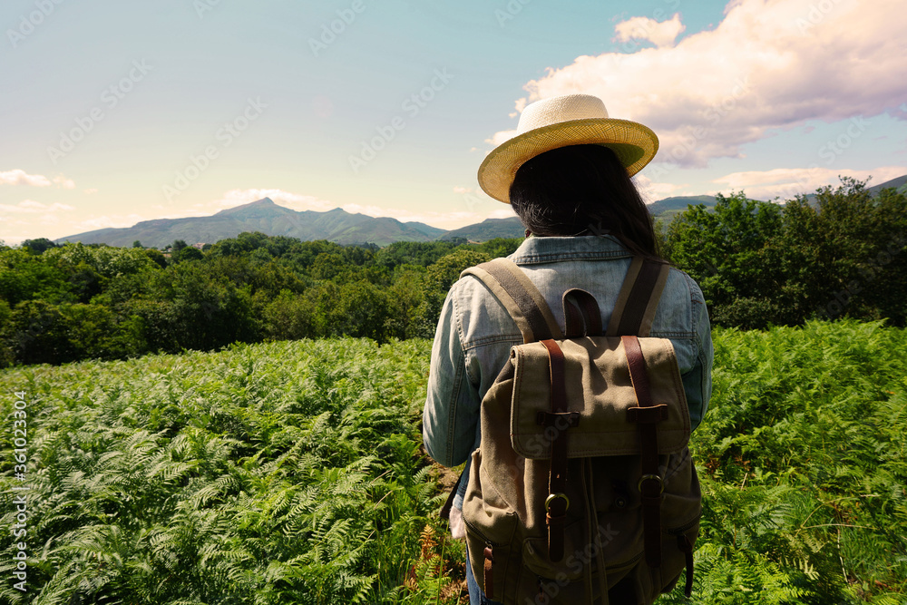 Woman with backpack on a journey in coutryside, wearing hat Woman with backpack on a journey in coutryside, wearing hat