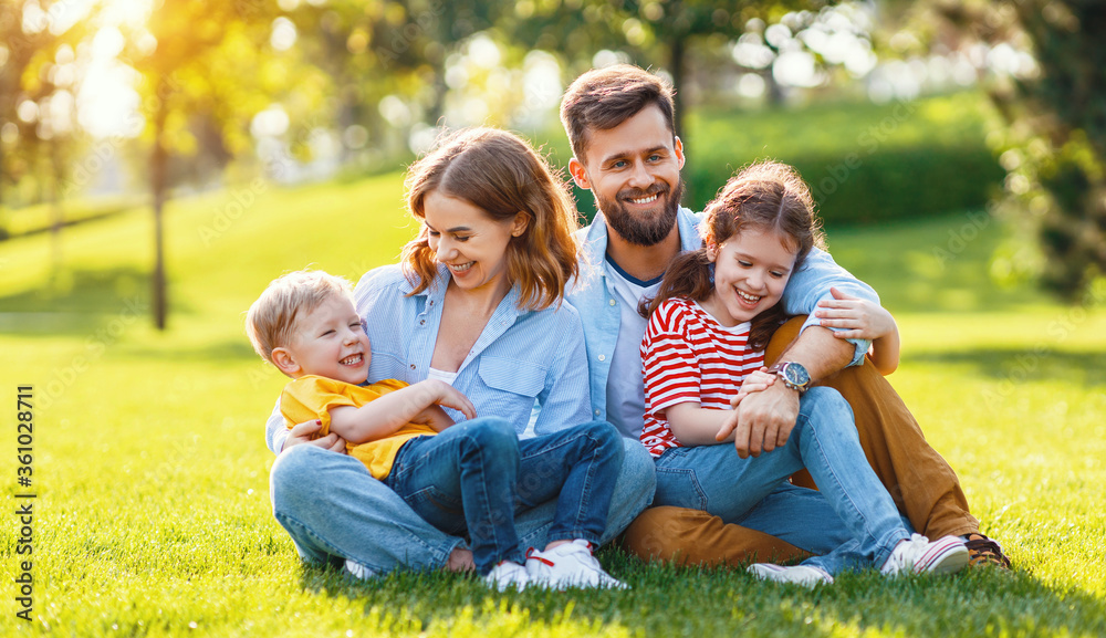 Happy family resting on lawn together. Happy family resting on lawn together.