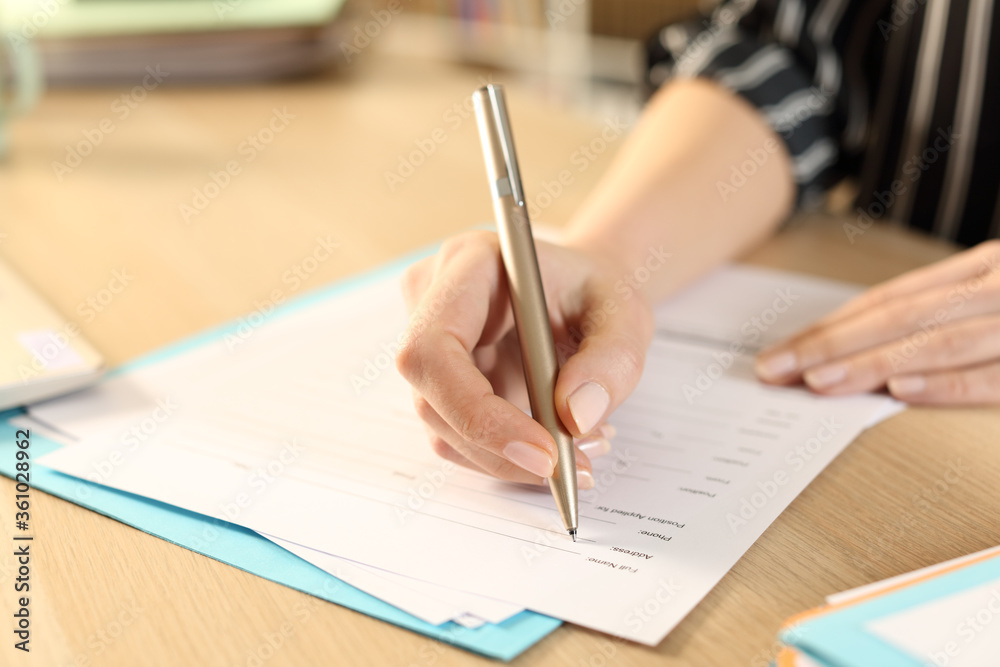 Woman hands filling out application form at home Woman hands filling out application form at home