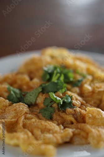 Angle view of Omelet top with coriander on wood table.(Thai style)