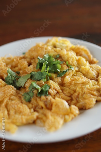 Angle top view of Omelet and top with coriander on wood table.(Thai style)