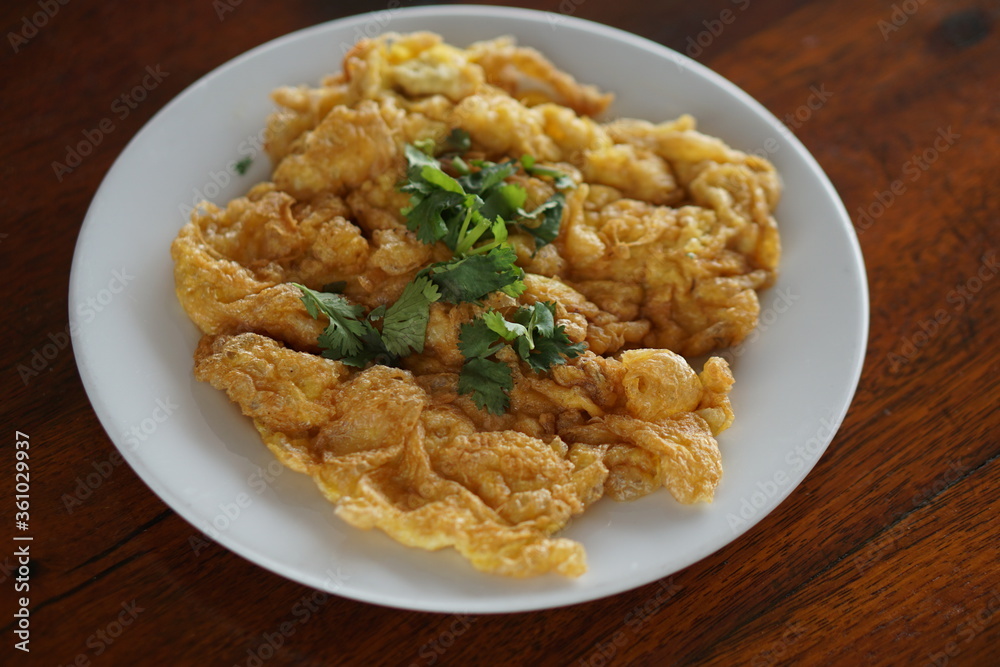 Close up top view of Omelet and top with coriander on wood table.(Thai style) Close up top view of Omelet and top with coriander on wood table.(Thai style)